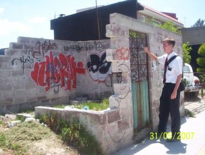 Photo of Elder Willoughby knocking on the door of an abandoned home
