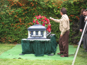 Pallbearer lays his flower on the casket.